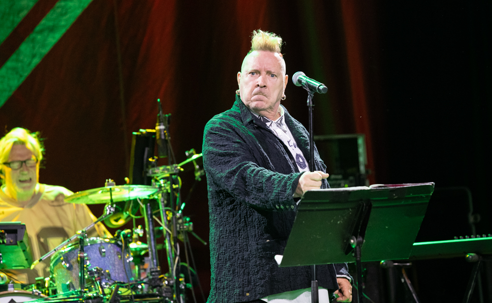The singer looking across the stage with the drummer behind him during PiL at Variety Playhouse in Atlanta.